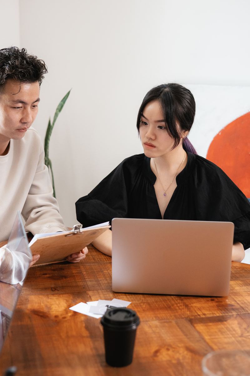 Two colleagues talking through a plan over a laptop