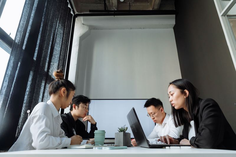 A small team working side by side at a long desk